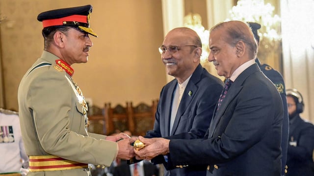 Prime Minister Shehbaz Sharif (R) and President Asif Ali Zardari (C) jointly conferring the Baton of Field Marshal on Asim Munir during a ceremony at the country's President House. 