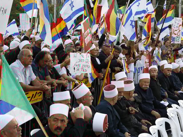 Members of the Israeli Druze community wave Druze and Israeli flags as they demonstrate  to protest against the 'Jewish Nation-State Law' in the Israeli coastal city of Tel Aviv on August 4, 2018. 
Tens of thousands of Israeli Druze and their supporters rallied in central Tel Aviv today to protest the new law they say makes them second-class citizens, an AFP reporter said.
The law, which passed last month and is part of Israel's so-called basic laws, a de facto constitution, proclaims the country the nation state of the Jewish people.
 / AFP PHOTO / JACK GUEZ tel aviv israel  drusos protestan contra la ley de nacionalidad ley define a Israel como Estado nacional del pueblo judio manifestantes de la minoría religiosa