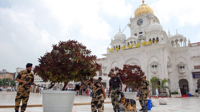 Security personnel with a sniffer dog frisk the surroundings of the Golden Temple in the wake of a fifth bomb threat, in Amritsar on Wednesday.