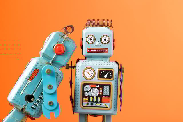 Stock image of one toy robot &#34;eating&#34; another.