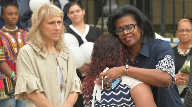 Baltimore City Schools CEO Dr. Sonja Santelises, right, hugs Rosa Funez, the mother of Ivan Carlos Oseguera-Funez, one of the eleven city school students lost to gun violence this school year. They were joined by Mayor Brandon Scott, school staff and families at the 7th annual Peace and Remembrance Day held outside North Avenue headquarters. (Amy Davis/Staff photo)