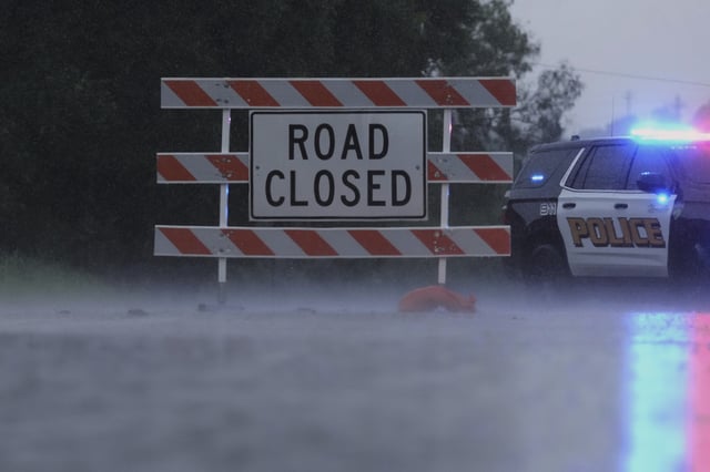 A barricade blocks a road during heavy rains, Sunday, July 13, 2025, in Kerrville, Texas. (AP Photo/Eric Gay)