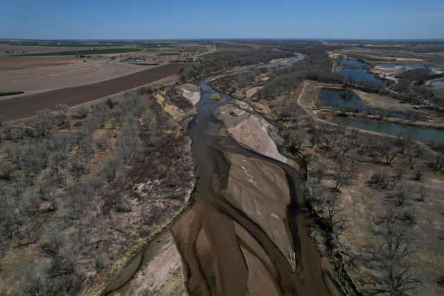 The South Platte River flows near Fort Morgan on Thursday, April 28, 2022. As climate change-fueled megadrought edges eastward, Nebraska wants to divert water in Colorado by invoking an obscure, 99-year-old compact between the states that allows Nebraska to seize Colorado land along the South Platte River to build a canal. (AP Photo/Brittany Peterson)