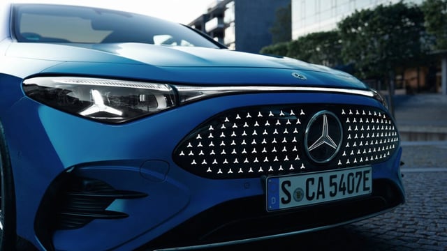 A closeup of the front of a blue Mercedes-Benz CLA with EQ technology.