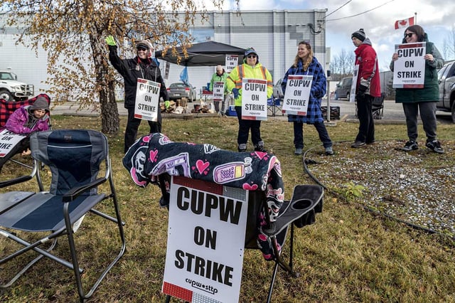 CUPW members wave to honking trucks as they strike along Penn Road in front of the mail sorting facility during last year's strike.