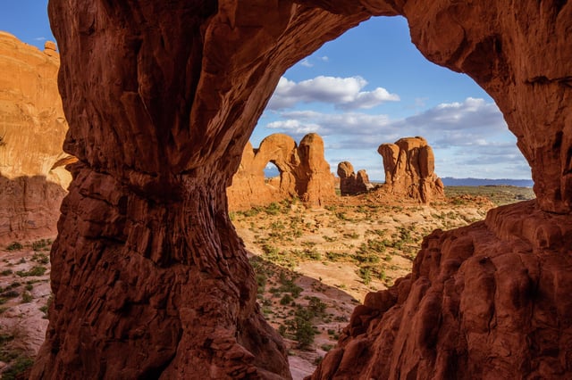 The Parade of Elephants and the back of Double Arch, which is framed by Cove Arch, in Arches National Park in Utah.