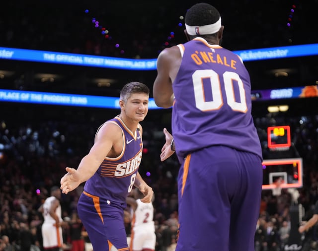 Phoenix Suns guard Grayson Allen (8) slaps hands with forward Royce O'Neale (00) after beating the Miami Heat 115-112 at Footprint Center in Phoenix on Nov. 6, 2024.