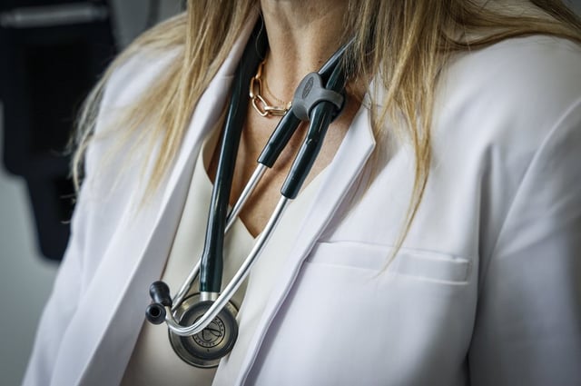 A doctor wears a lab coat and stethoscope in an exam room on Friday, July 14, 2023. 