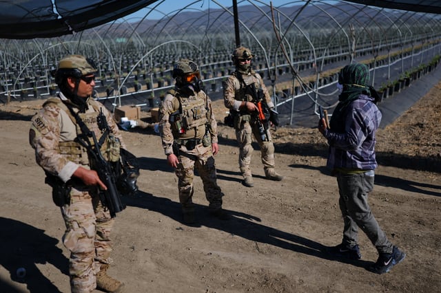 U.S. federal agents stand guard while blocking a road leading to an agricultural facility where U.S. federal agents and immigration officers carried out an operation, in Camarillo, California, U.S., July 10, 2025. REUTERS/Daniel Cole/File Photo