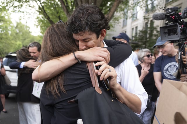 FILE - A fired State Department employee, left, is greeted outside of the Harry S. Truman Building, the headquarters of the State Department, in Washington, July 11, 2025. (AP Photo/Manuel Balce Ceneta, File)
