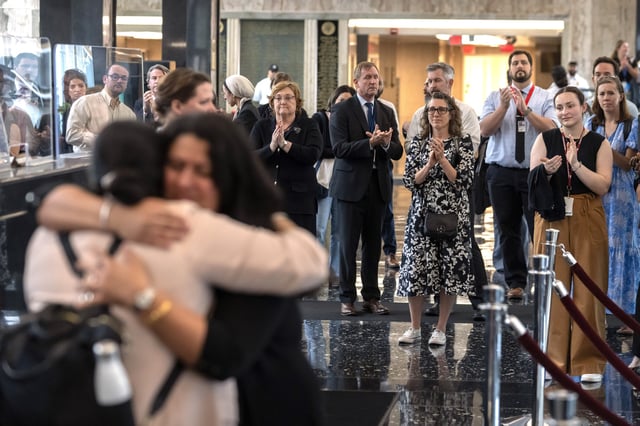 FILE - State Department employees applaud as their colleagues walk through the lobby of the State Department headquarters in the Harry S Truman Building, July 11, 2025, in Washington. (AP Photo/Mark Schiefelbein, File)