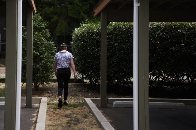 Havalah Hopkins, a single mother who lives in government-subsidized housing with her teenage son, goes to check on her son playing outside Thursday, July 10, 2025, in Woodinville, Wash. (AP Photo/Lindsey Wasson)