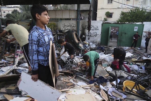 Palestinos inspeccionan los daños en una escuela que fue alcanzada en un mortífero ataque militar israelí en la ciudad de Gaza.
