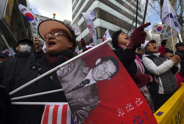 An activist holds a flag showing a portrait of former South Korean president Park Chung-hee in 2017