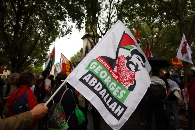 A protester holds a flag with the slogan "Freedom for Georges Abdallah" during a demonstration to demand the immediate and unconditional release of Georges Ibrahim Abdallah, a Lebanese militant held in France since 1984, on the eve of a French appeals court ruling on his conditional release, in Paris, France, July 16, 2025.  REUTERS/Abdul Saboor/File photo