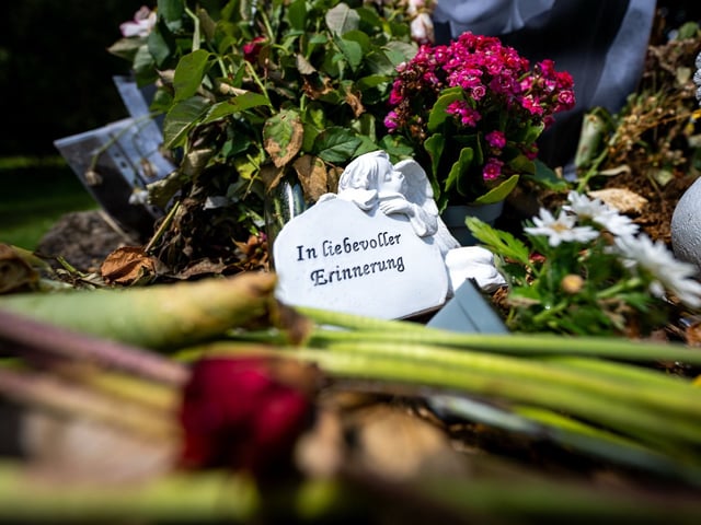 Thüringen, Zella-Mehlis: An einem Brunnen in der Nähe des Fundortes einer Männerleiche wurden Blumen und eine Engelsfigur abgelegt