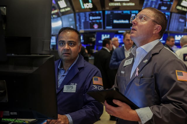 Traders work on the floor at the New York Stock Exchange (NYSE) in New York City, U.S., July 15, 2025. REUTERS/Jeenah Moon/File Photo