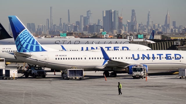 A ground personel walks in front of United Airlines planes prepare to take off at Newark Liberty International Airport in Newark, New Jersey, , U.S., January 27, 2025. REUTERS/Fabrizio Bensch/File Photo