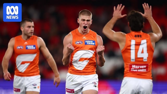 A GWS forward yells and pumps his fists in celebration after kicking a goal.