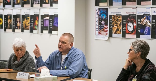 Inmate David Brom talked during the book club discussion as guests Maggie Shryer, left, and Kathi Koehn listened.