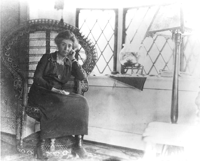 PORTRAIT OF MARY COLTER, AGE 50 SITTING IN A RATTAN CHAIR. CONTEMPLATIVE POSE. CIRCA 1919.  NPS COPYRIGHT.