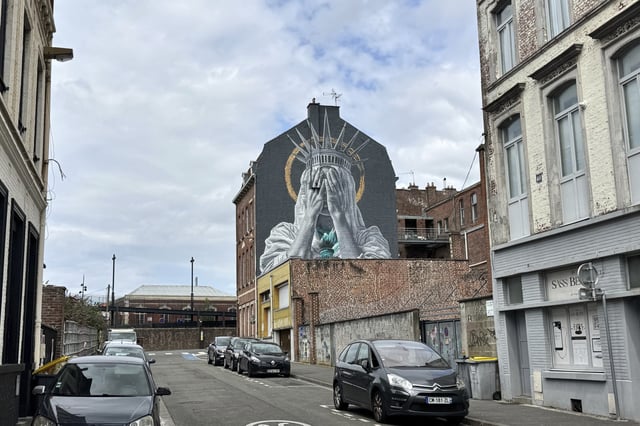 A mural by Dutch artist Judith de Leeuw shows the Statue of Liberty covering her eyes with her hands, in Roubaix, northern France, Monday, July 14, 2025. (AP Photo/Sylvain Plazy)