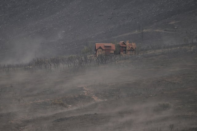 A structure saved by firefighters from the Turner Gulch fire is seen amid charred earth along Colorado 141 north of Gateway, Colorado on Wednesday, July 16, 2025. (Photo by Hyoung Chang/The Denver Post)