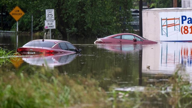 Two vehicles sit nearly fully submerged in floodwaters at Telephone Place and East 23rd Street on Thursday, July 17, 2025, in Kansas City. Heavy overnight rainfall caused flash flooding in parts of the city.