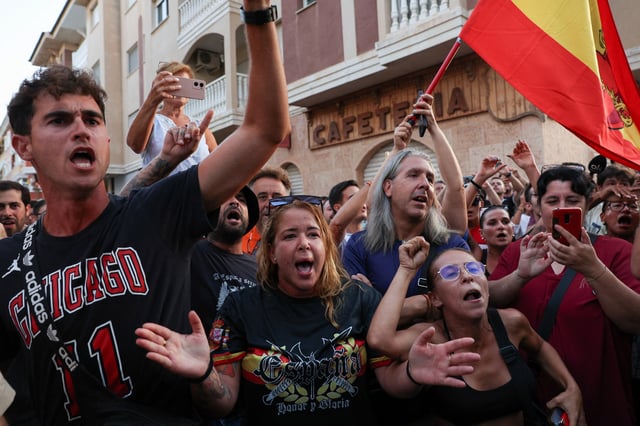 A demonstrator gestures while wearing a shirt reading, "Spain. Honour and Glory", during anti-migrant unrest, following an attack on an elderly man by unknown assailants last week, in Torre Pacheco, Spain, July 15, 2025. REUTERS/Violeta Santos Moura/File Photo