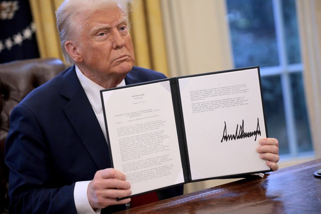 WASHINGTON, DC - JANUARY 30: U.S. President Donald Trump hold up a memorandum he signed ordering an immediate assessment of aviation safety and ordering an elevation of what he called “competence” over “D.E.I.” in the Oval Office at the White House on January 30, 2025 in Washington, DC. Trump also signed a executive order to appoint Chris Rocheleau as the deputy administrator of the Federal Aviation Administration. (Photo by Chip Somodevilla/Getty Images)