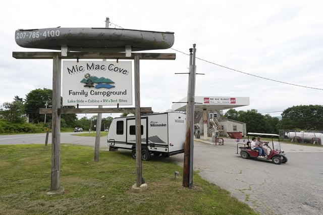 Campers ride a golf cart to the Mic Mac Cove Campground, Wednesday, July 9, 2025, in Union, Maine, where police have used the campground to access Crawford Pond to investigate the murder of a woman last seen paddleboarding on the pond. (AP Photo/Robert F. Bukaty)