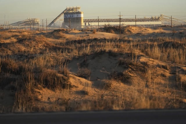A sand dune is backdropped by Atlas Energy plant at the beginning of a 68-kilometre conveyor belt that carries sand needed for hydraulic fracturing Wednesday, Feb. 26, 2025, in Kermit, Texas. (AP Photo/Julio Cortez)