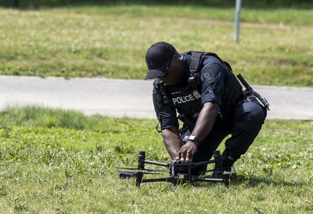 A police officer readies a drone as they search the St. Lawrence River for the body of a 32-year-old man who may have drowned at the Verdun Beach on Wednesday, July 16, 2025. THE CANADIAN PRESS/Christinne Muschi