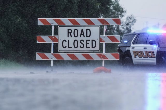 A barricade blocks a road during heavy rains, Sunday, July 13, 2025, in Kerrville, Texas.