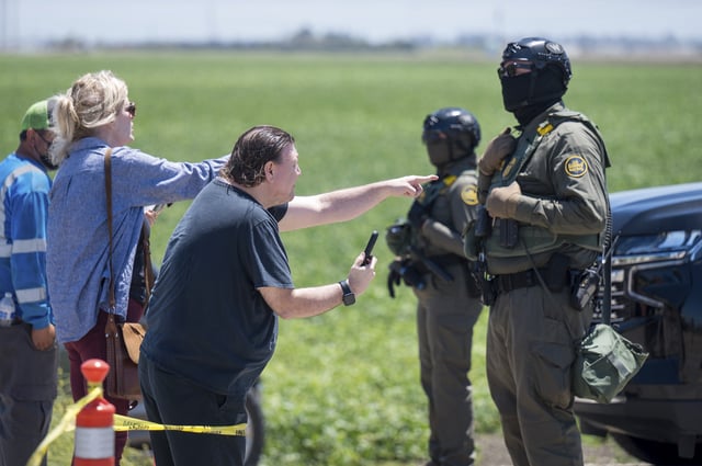 People shout at federal immigration agents during a raid in the agriculture area of Camarillo, Calif., July 10, 2025. (AP Photo/Michael Owen Baker)