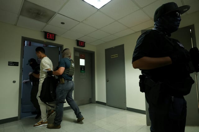 Un homme détenu par des agents fédéraux après une audience dans un tribunal d'immigration situé dans l'immeuble fédéral Jacob K. Javitz de New York, le 17 juillet 2025.