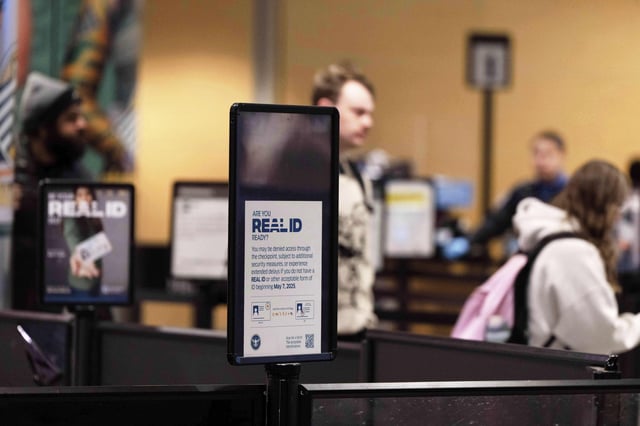 FILE - A sign for Real ID is seen as people walk through the security line at Anchorage airport, June 2, 2025, in Deadhorse, Alaska. (AP Photo/Jenny Kane, File)
