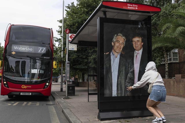 Activists put up a poster showing President Donald Trump and Jeffrey Epstein near the U.S. Embassy in London, Thursday, July 17, 2025.