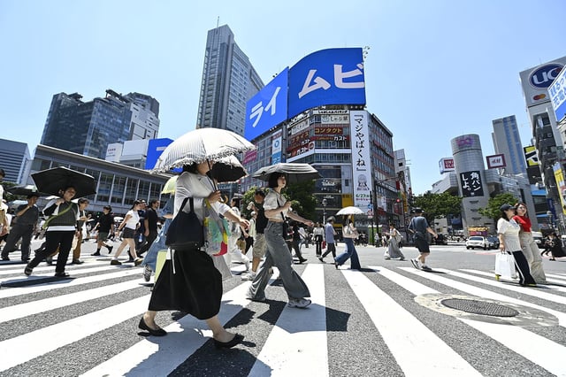 People cross the iconic Shibuya crossroad on June 17, 2025, in Tokyo, Japan.