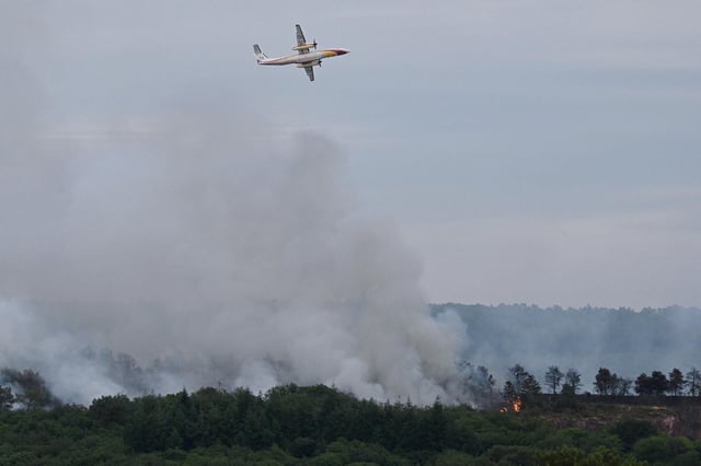 Un bombardier d’eau Dash 8-Q400 MR de la Sécurité civile largue de l’eau au-dessus de la forêt de Brocéliande après qu’un incendie s’est déclaré, le 17 juillet 2025 à Tréhorenteuc, dans le Morbihan
