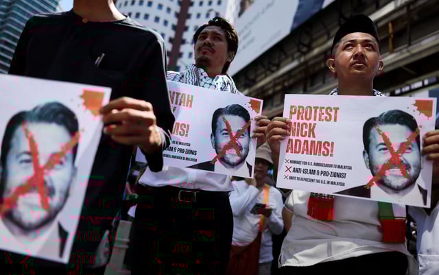 Protesters hold pictures of Nick Adams as they protest U.S. President Donald Trump's nomination of Nick as the U.S. ambassador to Malaysia, outside the U.S. Embassy in Kuala Lumpur, Malaysia July 18, 2025. REUTERS/Hasnoor Hussain