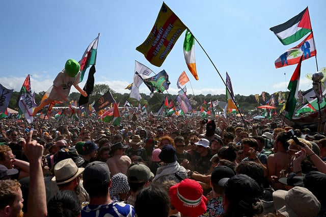 Revellers gather as Kneecap performs at Glastonbury Festival at Worthy Farm in Pilton, Somerset, Britain, June 28, 2025.