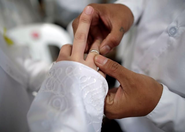 Una pareja intercambia los anillos durante la celebración de su boda.
