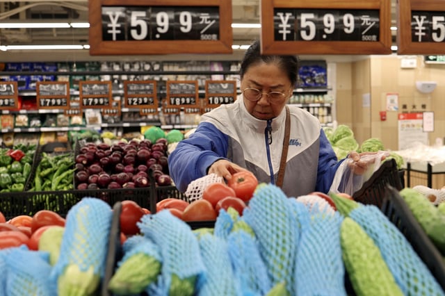 A customer shops for tomatoes at the vegetable section of a supermarket in Beijing, China October 17, 2024. REUTERS/Florence Lo/File Photo