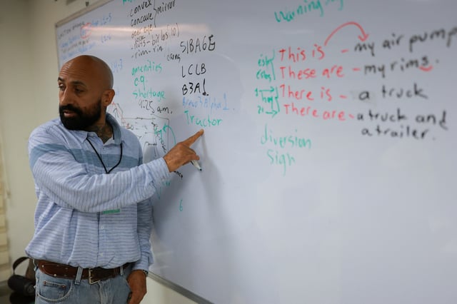 Ernesto Montes teaches English to Mexican truck drivers as part of an effort to comply with a recent executive order by U.S. President Donald Trump requiring commercial drivers to meet English proficiency standards, at the Fletes Sotelo company facilities in Ciudad Juarez, Mexico July 16, 2025. REUTERS/Jose Luis Gonzalez