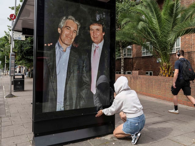 Activists put up a poster showing President Donald Trump and Jeffrey Epstein near the U.S. Embassy in London, Thursday, July 17, 2025.(AP Photo/Thomas Krych)