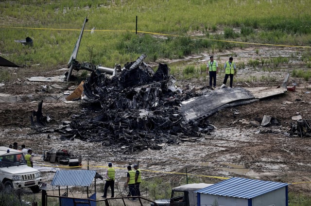 Officials from the airport stand near the wreckage of a Saurya Airlines plane that caught fire after skidding off the runway while taking off at Tribhuvan International Airport, in Kathmandu, Nepal, July 24, 2024. REUTERS/Navesh Chitrakar/File Photo