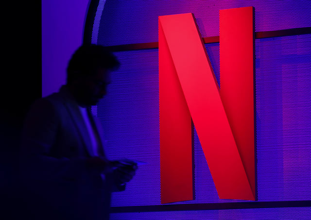 A man stands next to a logo of Netflix during an event in Mumbai, India, February 29, 2024. REUTERS/Francis Mascarenhas/File Photo