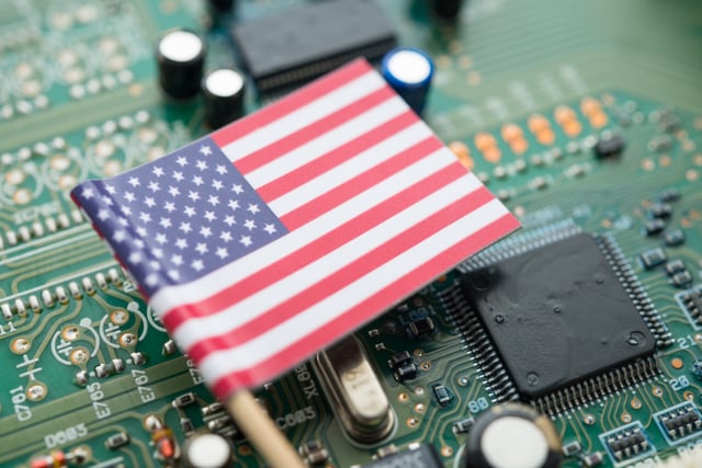 A U.S. flag on a green circuit board background (via Getty Images)