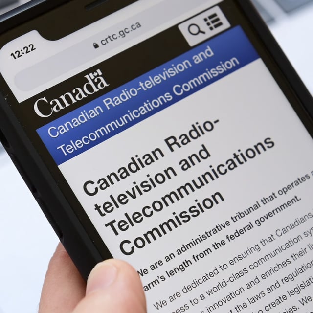 A person navigates to the on-line social-media pages of the Canadian Radio-television and Telecommunications Commission (CRTC) on a cell phone in Ottawa on Monday, May 17, 2021. The Aboriginal Peoples Television Network says that in the face of shrinking resources that are making it more difficult to tell Indigenous stories, online streaming services should be required to contribute funding to the Canadian broadcasting system. THE CANADIAN PRESS/Sean Kilpatrick